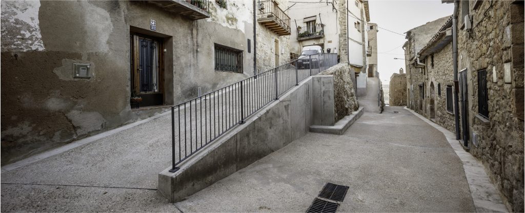 Pavimentació contínua, baranes i desguassos a la zona del Castell