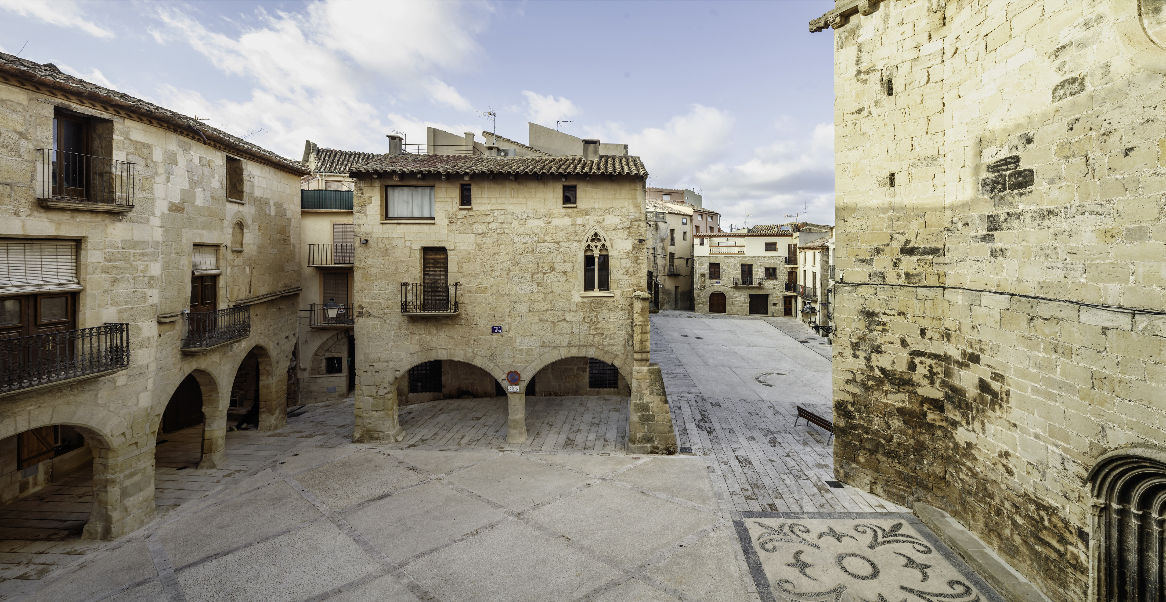 La Plaça de l’Església amb la seva característica porxada i al fons, la plaça de Sant Salvador